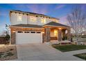 A charming two-story home with a stone-accented entrance and a wide driveway leading to an attached two-car garage at 11582 Jimenez St, Parker, CO 80134