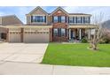 Charming two-story home with a three-car garage and a lush green lawn at 20534 E Union Cir, Aurora, CO 80015