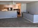 Open living area flows to the kitchen featuring gray walls, breakfast bar and views to the in-unit laundry at 5866 W Asbury Pl, Lakewood, CO 80227