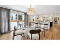 Sunlit dining area with a modern chandelier and sliding doors to the outdoor space at 6279 E Princeton Ave, Cherry Hills Village, CO 80111