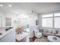 Sun-filled living room with hardwood floors, dining area, and sliding door to balcony at 6001 S Yosemite St # B206, Greenwood Village, CO 80111