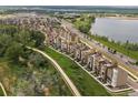 Aerial view showcasing the well-maintained townhomes near a serene lake and walking path at 2468 Channel Dr, Highlands Ranch, CO 80129