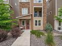 Charming townhouse exterior with stone accents, inviting entrance, and lovely landscaping at 2468 Channel Dr, Highlands Ranch, CO 80129