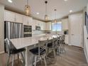 Bright, open kitchen with white cabinets, stainless appliances, and a large island with seating at 2468 Channel Dr, Highlands Ranch, CO 80129