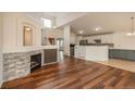Open-concept living area with hardwood floors, fireplace, and view into the kitchen at 23955 Glenmoor Way, Parker, CO 80138