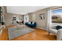 Bright living room boasts hardwood floors, a cozy rug, and ample natural light from large windows at 2259 Meade St, Denver, CO 80211