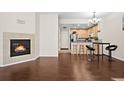 Open-concept living room with hardwood floors, a fireplace, and a kitchen with a breakfast bar at 15945 E Geddes Dr # 54, Aurora, CO 80016