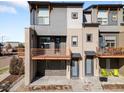 Two-story townhome with multiple balconies, stylish doors, and outdoor seating provides urban charm at 10051 Belvedere Cir, Lone Tree, CO 80124