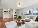 Bright living room featuring hardwood floors, a large window, a comfortable sofa and modern decor at 10335 W 18Th Pl, Lakewood, CO 80215
