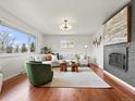 Inviting living room with hardwood floors, a fireplace, a comfortable sofa and abundant natural light at 10335 W 18Th Pl, Lakewood, CO 80215