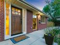 Charming brick home with a stylish front door, warm lighting, and lovely landscaping at 207 Iowa Dr, Golden, CO 80403