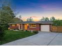 Brick home with a well-kept lawn, driveway, and an attached garage for added convenience at 207 Iowa Dr, Golden, CO 80403