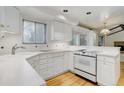 Well-lit kitchen with white cabinetry, modern stove, and hardwood floors at 3026 S Alton Ct, Denver, CO 80231