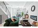 Bright living room with staircase, stylish decor and contemporary fireplace, flowing into dining area for seamless entertaining at 4394 Zenobia St, Denver, CO 80212