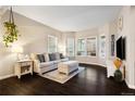 Cozy living room featuring large windows, plush seating, stylish decor, and hardwood floors at 4286 S Cole St, Morrison, CO 80465