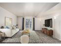 Bright living room featuring a modern sofa, stylish decor, and a sliding glass door to a balcony at 1273 S Gilbert St # A103, Castle Rock, CO 80104