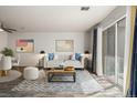 Bright living room with modern furniture, a decorative rug, and a sliding door to a balcony at 1273 S Gilbert St # A103, Castle Rock, CO 80104