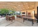 Spacious covered patio equipped with dining, lounge area, ping pong, and a mounted TV at 6830 Lamar St, Arvada, CO 80003