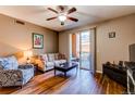 Bright living room featuring wood floors, ceiling fan, and access to a private outdoor balcony at 1651 W Canal Cir # 613, Littleton, CO 80120