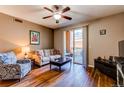 Inviting living room featuring a ceiling fan, hardwood floors, sofa, and sliding glass door to the balcony at 1651 W Canal Cir # 613, Littleton, CO 80120