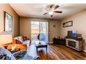 Cozy living room featuring hardwood floors, a ceiling fan, and a fireplace at 1651 W Canal Cir # 613, Littleton, CO 80120