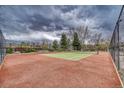 Outdoor tennis court featuring a red surface, green playing area, and surrounding fence at 1302 S Parker Rd # 127, Denver, CO 80231
