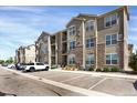Apartment building exterior featuring balconies, stone accents, and designated parking spaces at 9227 Rolling Way # 201, Parker, CO 80134