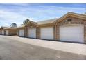 Row of detached garages with white doors and brick accents, providing convenient parking at 9227 Rolling Way # 201, Parker, CO 80134