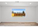 Bright, empty room featuring beautiful backyard view from a large window and light, modern flooring at 469 S Perry St, Denver, CO 80219