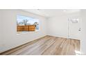 Bright living room features a large window, modern flooring, fresh paint and a front door at 469 S Perry St, Denver, CO 80219