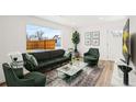 Bright living room featuring a large window, hardwood floors, modern decor, and comfortable green furniture at 469 S Perry St, Denver, CO 80219