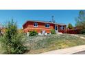 Red brick house on a grassy lot with a tree stump in the yard at 2533 E 90Th Pl, Thornton, CO 80229