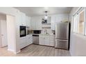 Bright kitchen featuring white cabinets, stainless steel appliances, and neutral flooring at 2533 E 90Th Pl, Thornton, CO 80229