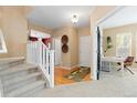 Inviting entryway with hardwood floors, staircase with white railing, and neutral paint throughout at 2488 Lake Vista Dr, Broomfield, CO 80023