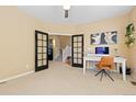 This office features neutral walls, carpet flooring, and black french doors leading to the entryway at 2488 Lake Vista Dr, Broomfield, CO 80023