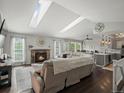 Sunlit living room with fireplace, skylights, and open floor plan to the kitchen at 5342 S Halifax Cir, Centennial, CO 80015
