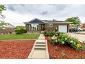 Inviting brick home boasts a well-manicured lawn and garden, solar panels and an attached garage at 10478 Ogden St, Northglenn, CO 80233