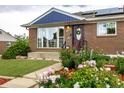 Charming brick home featuring beautiful landscaping with colorful flowers and a well-maintained front yard at 10478 Ogden St, Northglenn, CO 80233