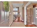 Welcoming entryway with hardwood floors, a large mirror, and an open view of the staircase and living area at 8726 Gardenia Cir, Arvada, CO 80005