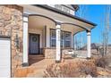 Inviting front porch with swing, stone accents, and stylish curb appeal enhances this charming home at 8726 Gardenia Cir, Arvada, CO 80005