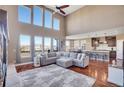 Spacious living room featuring high ceilings, large windows, and an open layout to the kitchen at 8726 Gardenia Cir, Arvada, CO 80005