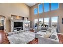 Living room featuring a stone fireplace, large windows, and comfortable sectional sofa at 8726 Gardenia Cir, Arvada, CO 80005