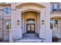Grand front entrance featuring a double door, arched entryway, and elegant lighting fixtures for a welcoming appeal at 10162 Prestwick Trl, Lone Tree, CO 80124