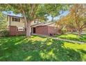 Traditional two-story home with a brick facade and green lawn at 8150 S Marshall Ct, Littleton, CO 80128