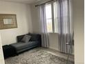 Cozy bedroom with a comfortable chaise lounge, soft rug, and bright natural light at 2617 Channel Dr, Highlands Ranch, CO 80129
