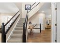 Entryway boasts hardwood floors, a staircase with dark wood trim, and a view into the living room at 6772 Tiger Tooth, Littleton, CO 80124