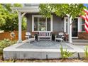 Inviting front porch is staged with white chairs, a cushioned bench, patterned area rug, and decorative planters at 6772 Tiger Tooth, Littleton, CO 80124