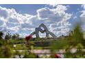 Modern sculpture in the community with vibrant green landscaping and bright blue skies at 8628 Hotchkiss St, Littleton, CO 80125