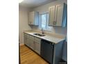 A well-lit kitchen with new light-grey cabinets, modern countertops, and hardwood floors at 6029 S Sycamore St, Littleton, CO 80120