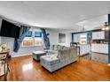 Bright living room featuring hardwood floors, a comfortable gray sofa, and large windows at 4269 Freeport Way, Denver, CO 80239
